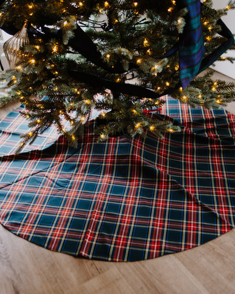 a Black Stewart tartan christmas tree skirt under a lit tree
