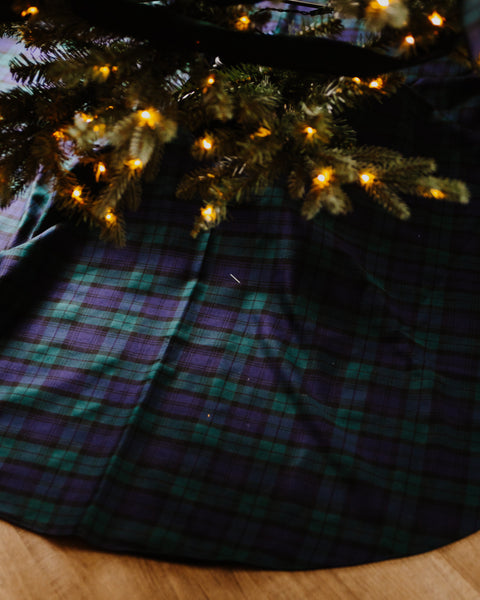 Black watch tartan christmas tree skirt under a lit christmas tree