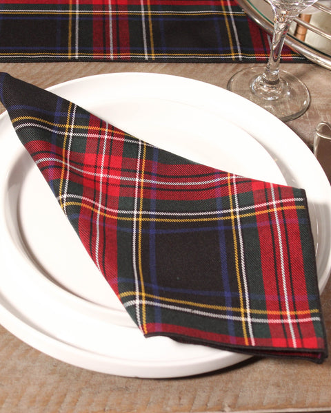 Black red green white and yellow Plaid napkin on a white plate with a tartan tablecloth in the background