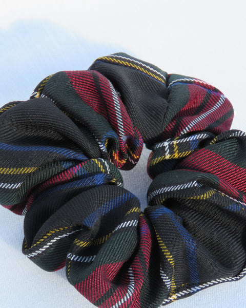 Black red white blue yellow Plaid tartan patterned scrunchies on a light blue background
