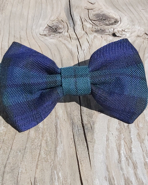 Green and navy plaid dog  bow tie on a wooden surface