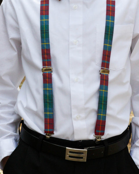 Person wearing a white shirt with British columbia tartan suspenders and a black belt.