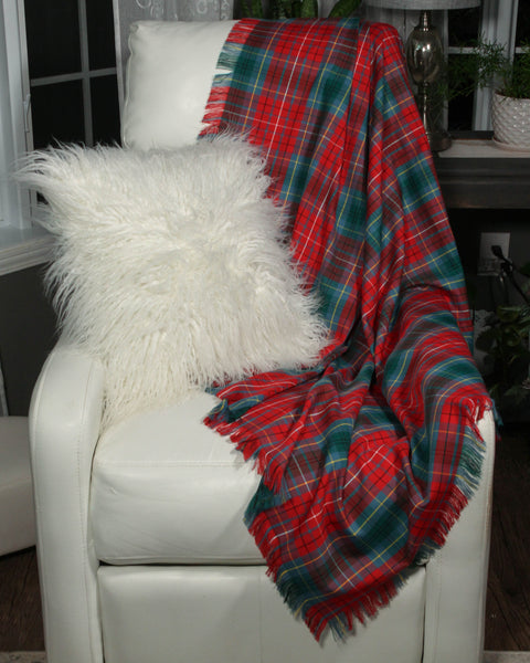 Red and green plaid blanket draped over a white chair with a fluffy white pillow.