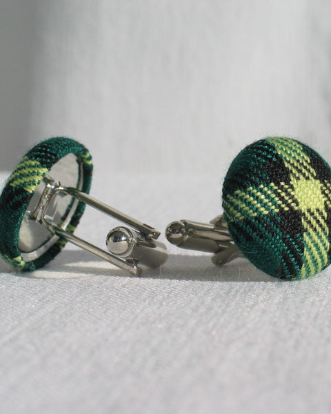 Side view of Green plaid cufflinks on a white background