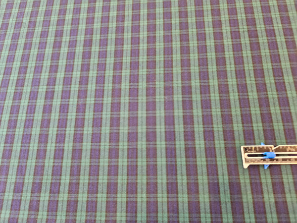 Green and navy plaid cotton fabric with ruler to measure scale of the fabric