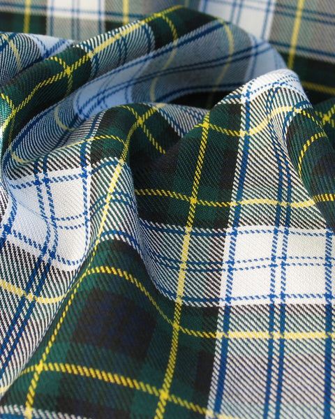 Close-up of plaid fabric with green, blue, and yellow patterns.