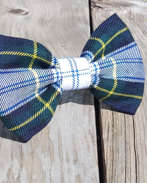 Plaid bow tie with blue, green, and yellow colors on a wooden surface