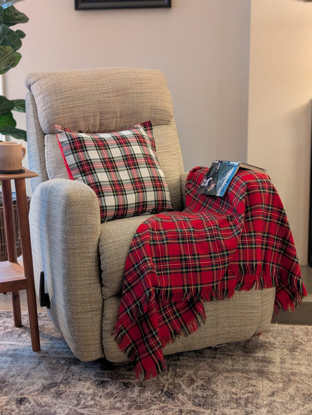 Beige recliner chair with plaid pillow and red blanket in a home setting