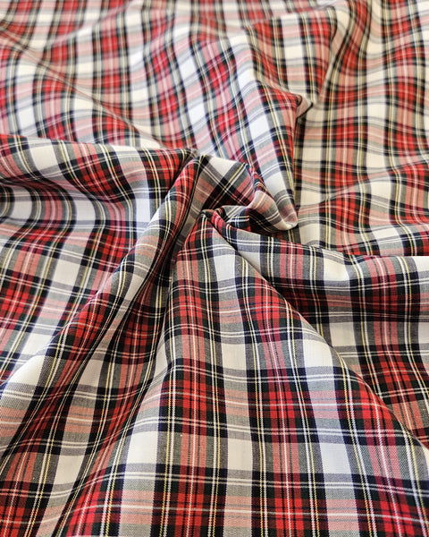 Close-up of plaid fabric with red, white, and black colors in Dress Stewart tartan cotton fabric