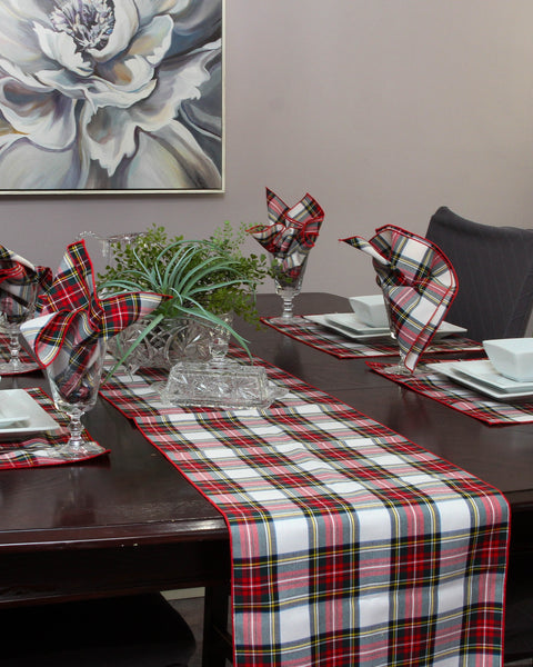 Dining table set with whtie and red plaid table runner, napkins, and decor.