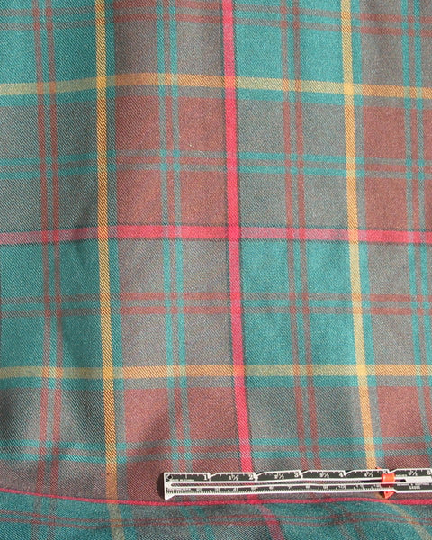 Plaid fabric with red, green, and yellow pattern on a plain background