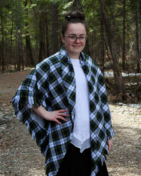 Person wearing a Gordon tartan plaid shawl in a forest setting