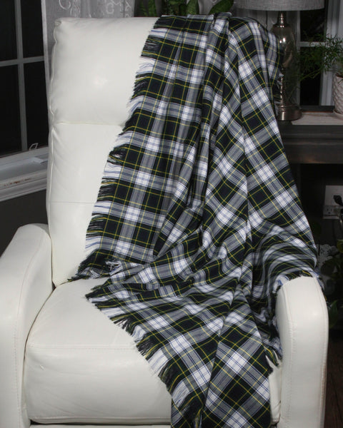 Plaid blanket draped over a white chair in a room setting.