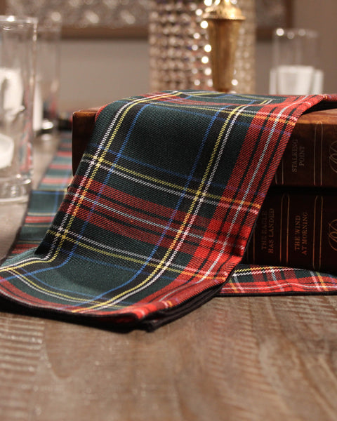 Green Stewart green navy and black Plaid napkin on a wooden table with books underneath