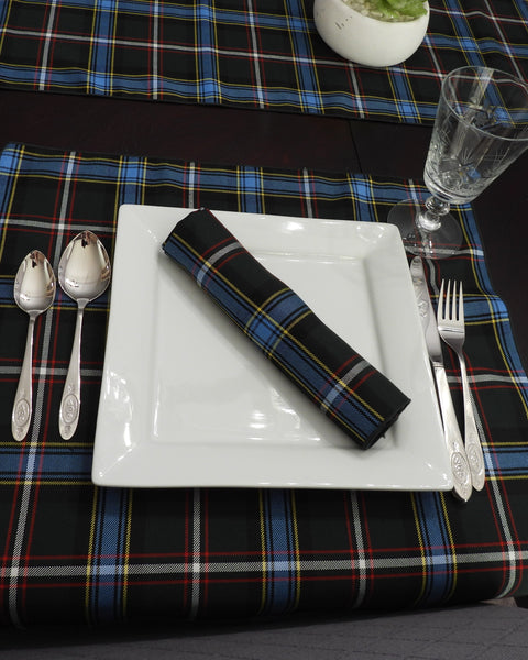 Dinner setting with a square plate, cutlery, and Labrador tartan plaid tablecloth and napkins.
