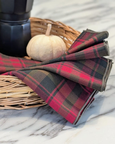 Canadian Maple Leaf Plaid napkins in a wicker basket on a marble surface with a pumpkin.