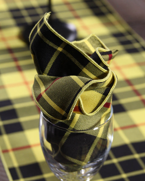 Yellow and black plaid napkin in wine glass on McLeod of Lewis tartan table runner