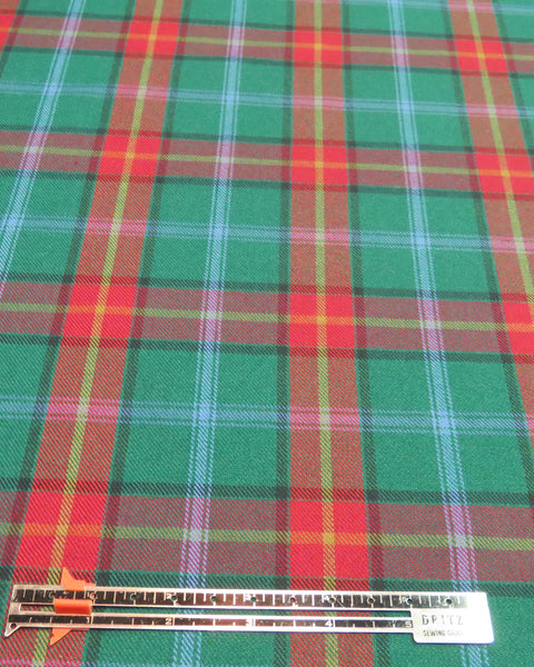 Plaid fabric with a ruler for scale on a green, red, and yellow pattern in Manitoba tartan