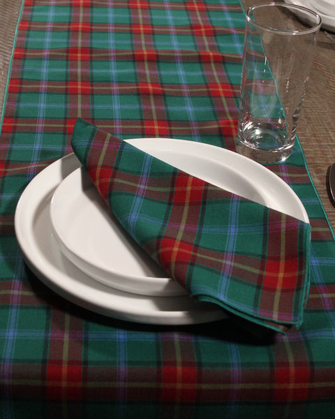 Manitobia tartan Plaid tablecloth with a white plate, glass, and plaid napkin on a table.