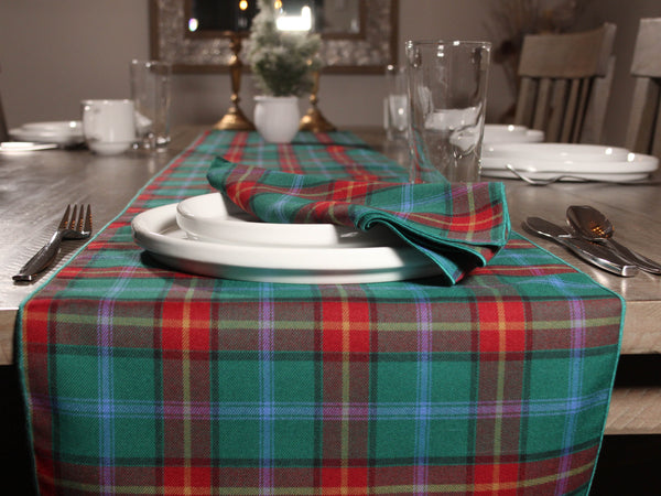 Dining table set with a Manitobe tartan plaid tablecloth, plates, and cutlery.