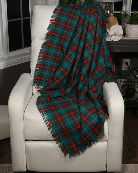 Plaid blanket draped over a white chair in a room with decor elements.
