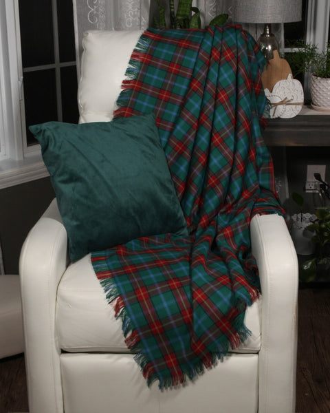 Manitoba tartan plaid blanket draped over a white chair with a green pillow