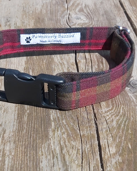 Red, brown and gold plaid dog collar made by Taylors Tartan laying on a wooden surface