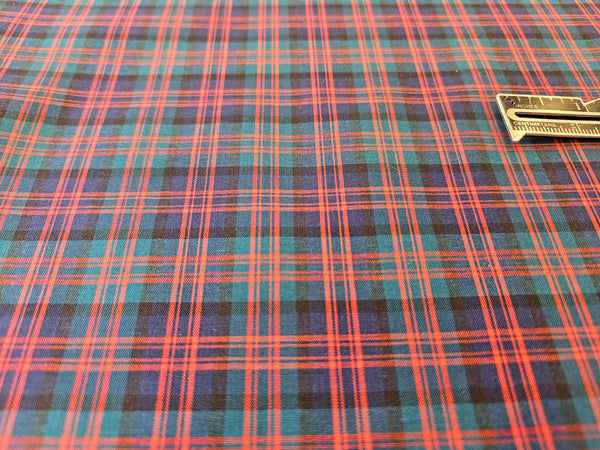 navy, red and green plaid cotton fabric with a ruler to measure scale