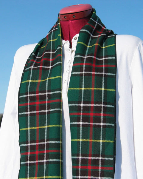 Green plaid scarf draped over a mannequin against a blue sky.