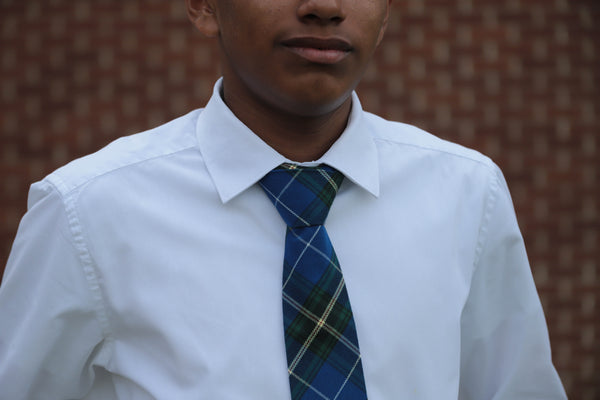 Close-up of blue and white plaid neck tie against a white shirt worn by  a young man.