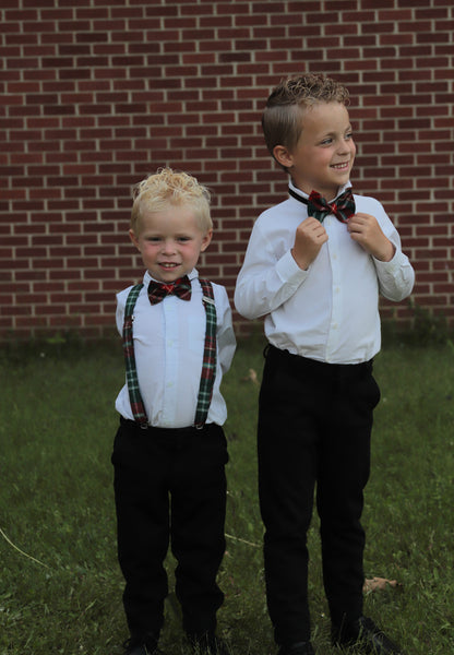 2 young boys wearing New Brunswick tartan green, blue, gold and red plaid suspenders with matching bowties.