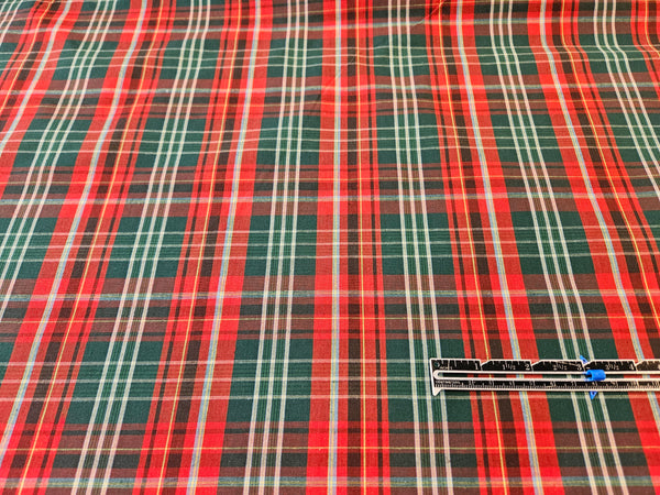 red, green and white plaid cotton fabric with a ruler for size comparison