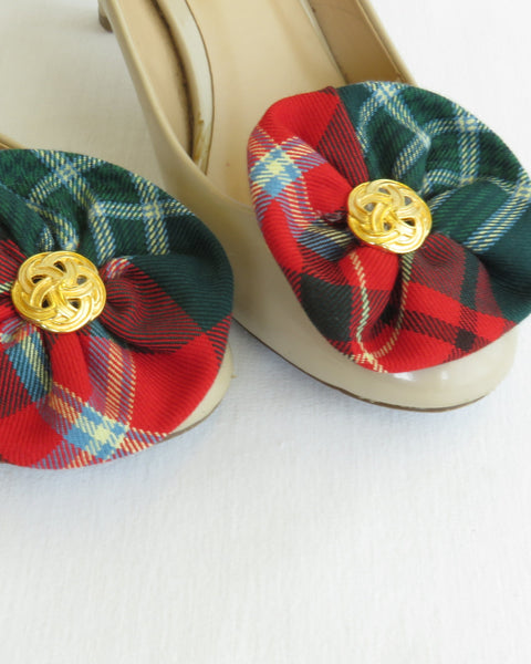 Shoes with red and green plaid flower shoe clip and gold buttons on a white background