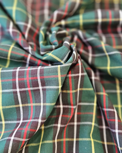 Close-up of plaid fabric with green, red, and brown colors.