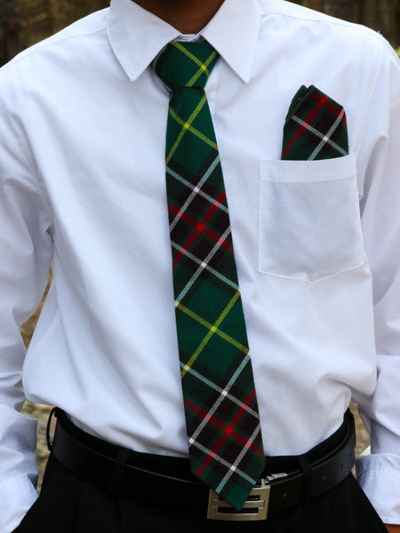 Person wearing a white shirt with a green plaid tie and matching pocket square.