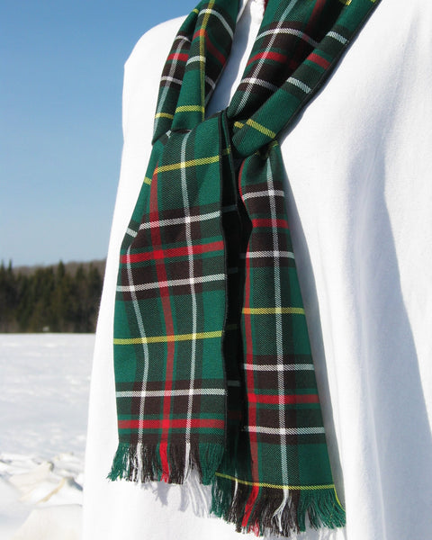 Green plaid Newfoundland scarf on a white mannequin against a snowy background with blue sky