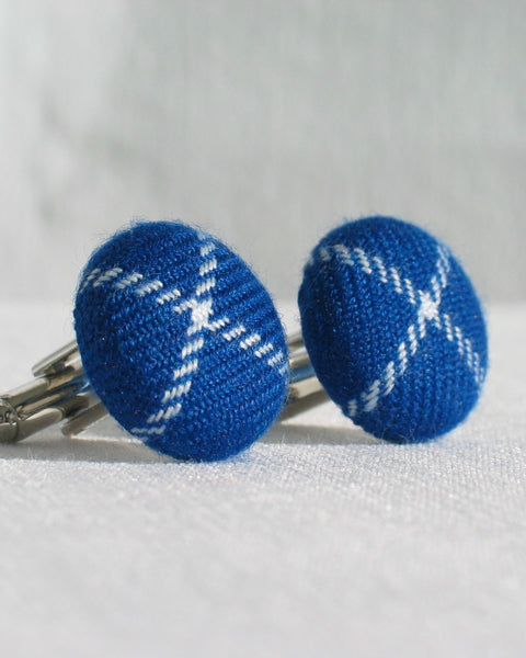 Blue and white patterned cufflinks on a light gray background