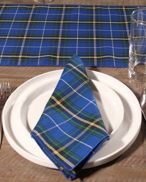 Nova Scotia Plaid napkin on a white plate with a blue plaid tablecloth in the background