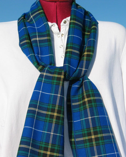 Blue green white plaid scarf draped over a white shirt 