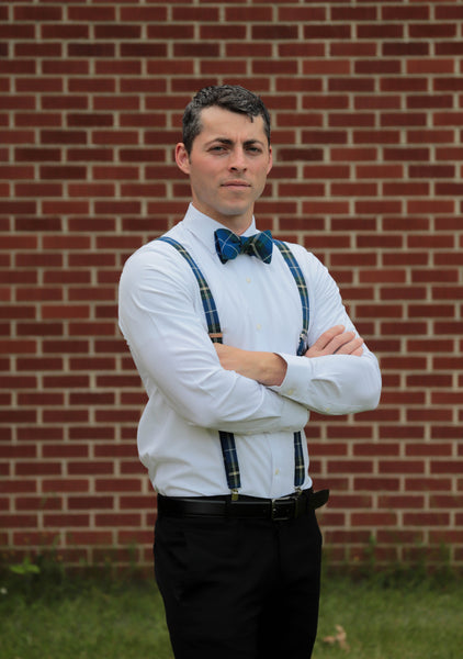 Man wearing Nova Scotia tartan blue, white, and yellow plaid suspenders with matching pre-tied bowtie on a white shirt with black dress pants.