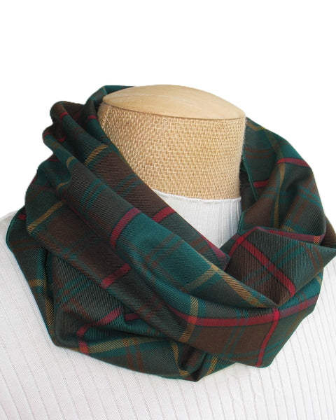 Green, red, and gold plaid scarf on a mannequin head against a white background