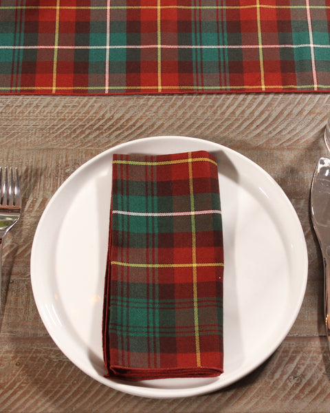 Plaid napkin on a white plate with cutlery on a wooden table