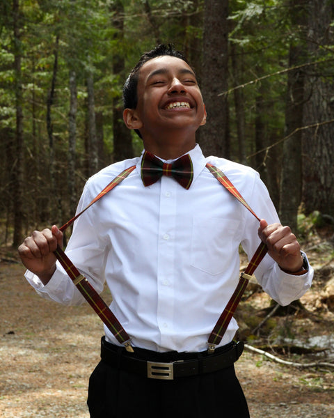 Person wearing Prince Edward Island tartan suspenders and a bow tie in a forest setting