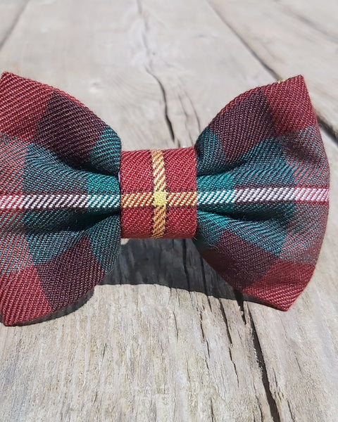 Rust, green and yellow plaid bow tie  in Prince Edward Island tartan on a wooden surface