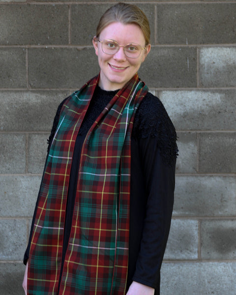 Person wearing a Prince Edward Island plaid scarf in front of a brick wall