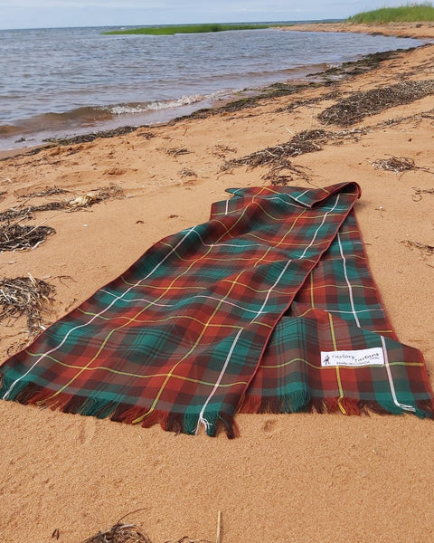 Plaid scarf on a PEI sandy beach with water in the background