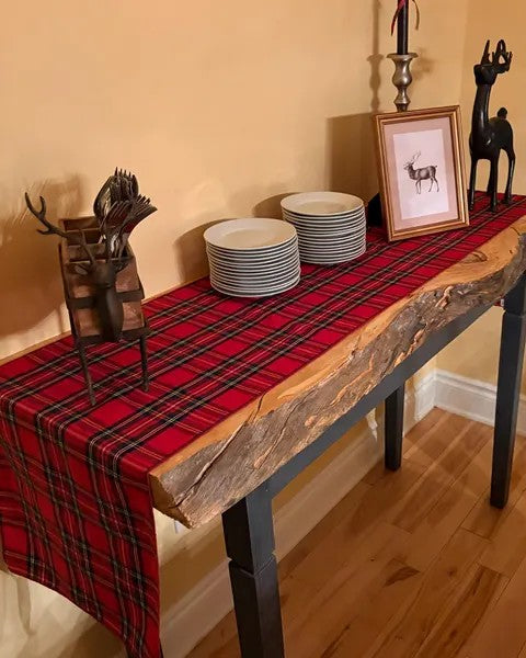 Raw Edge end table with a red plaid tablecloth, plates, and decorative items.
