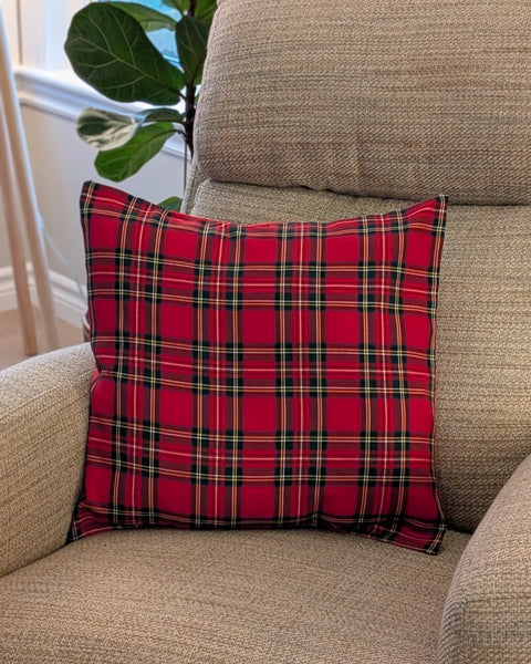 Red plaid pillow on a beige armchair with a plant in the background, Royal Stewart tartan pillow cover