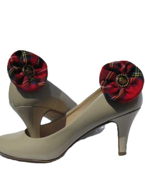 Beige high-heeled shoe with red and black plaid flower shoe clip on a white background