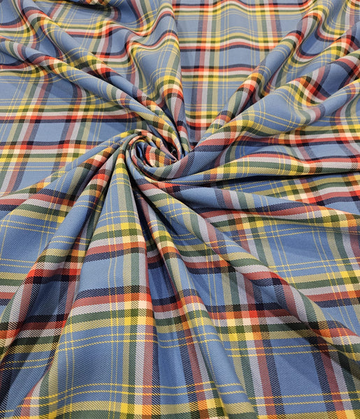 sky blue, yellow, white and red plaid fabric scrunched on a flat surface in Yukon tartan